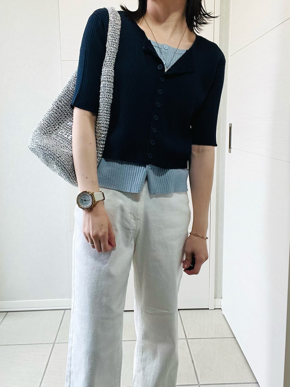 ブルー系のニット/セーター、ホワイト系のデニムパンツ、ブラック系のバレエシューズを着用したレディースの春コーディネートの2枚目の写真