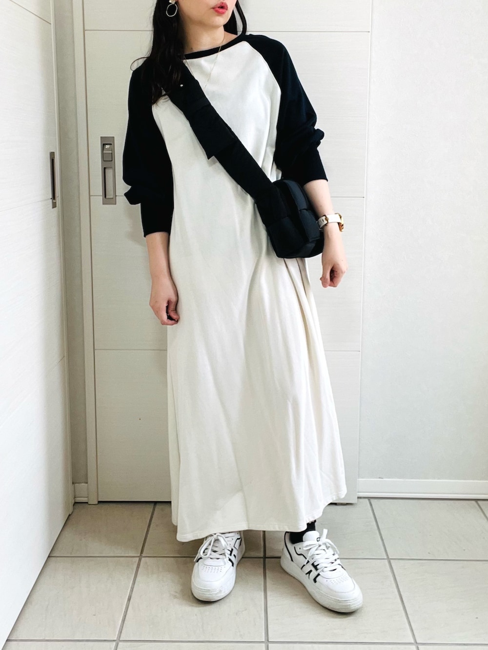 ホワイト系のワンピース、ホワイト系のスニーカー、ブラック系のショルダーバッグを着用したレディースの秋コーディネートの4枚目の写真