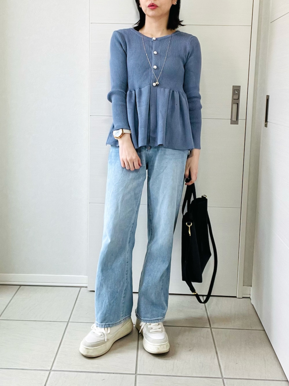グレー系のカーディガン/ボレロ、ブルー系のデニムパンツ、ホワイト系のスニーカーを着用したレディースの春コーディネートの3枚目の写真