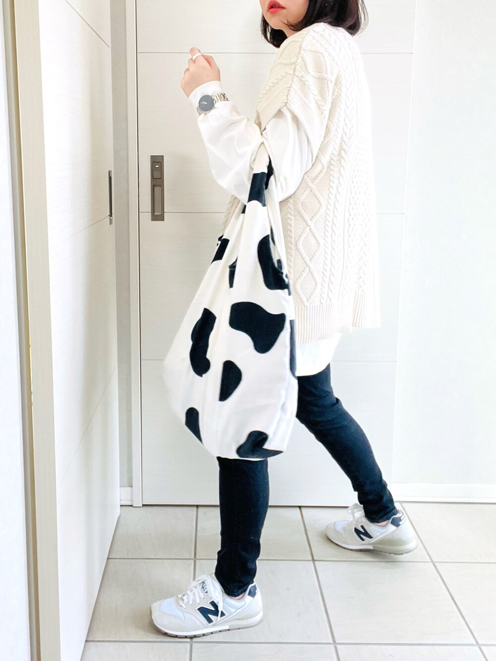 ブラック系のデニムパンツ、ホワイト系のスニーカー、ホワイト系のエコバッグ/サブバッグを着用したレディースの春コーディネートの5枚目の写真