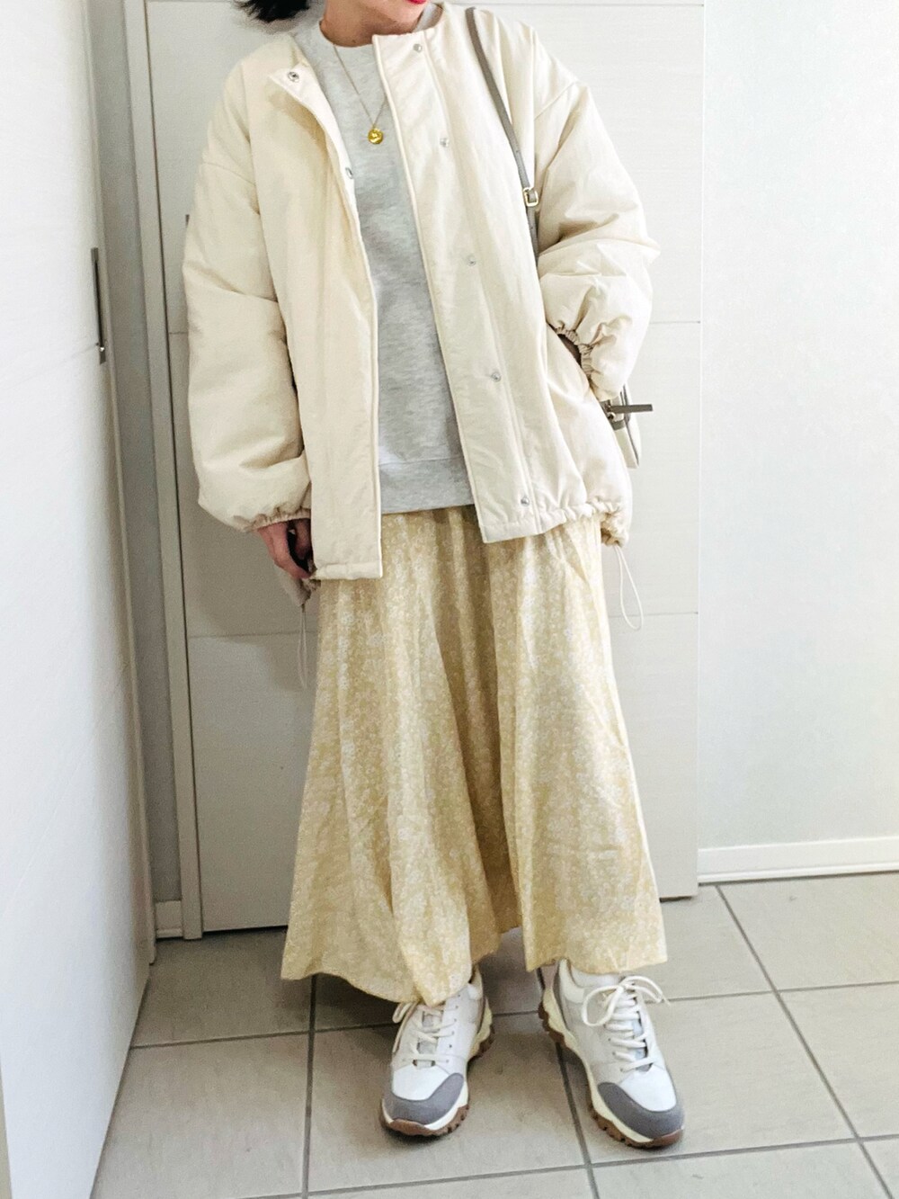 ホワイト系のブルゾン、グレー系のスウェット、イエロー系のスカートを着用したレディースの冬コーディネートの2枚目の写真