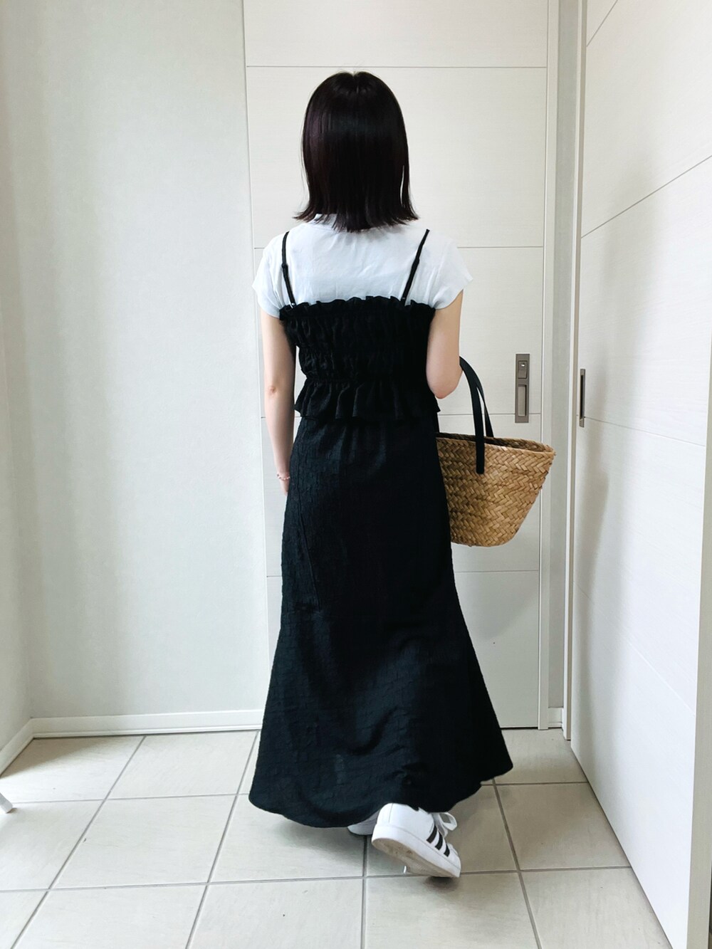 ブラック系のワンピース、ホワイト系のスニーカー、ブラック系のかごバッグを着用したレディースの夏コーディネートの4枚目の写真