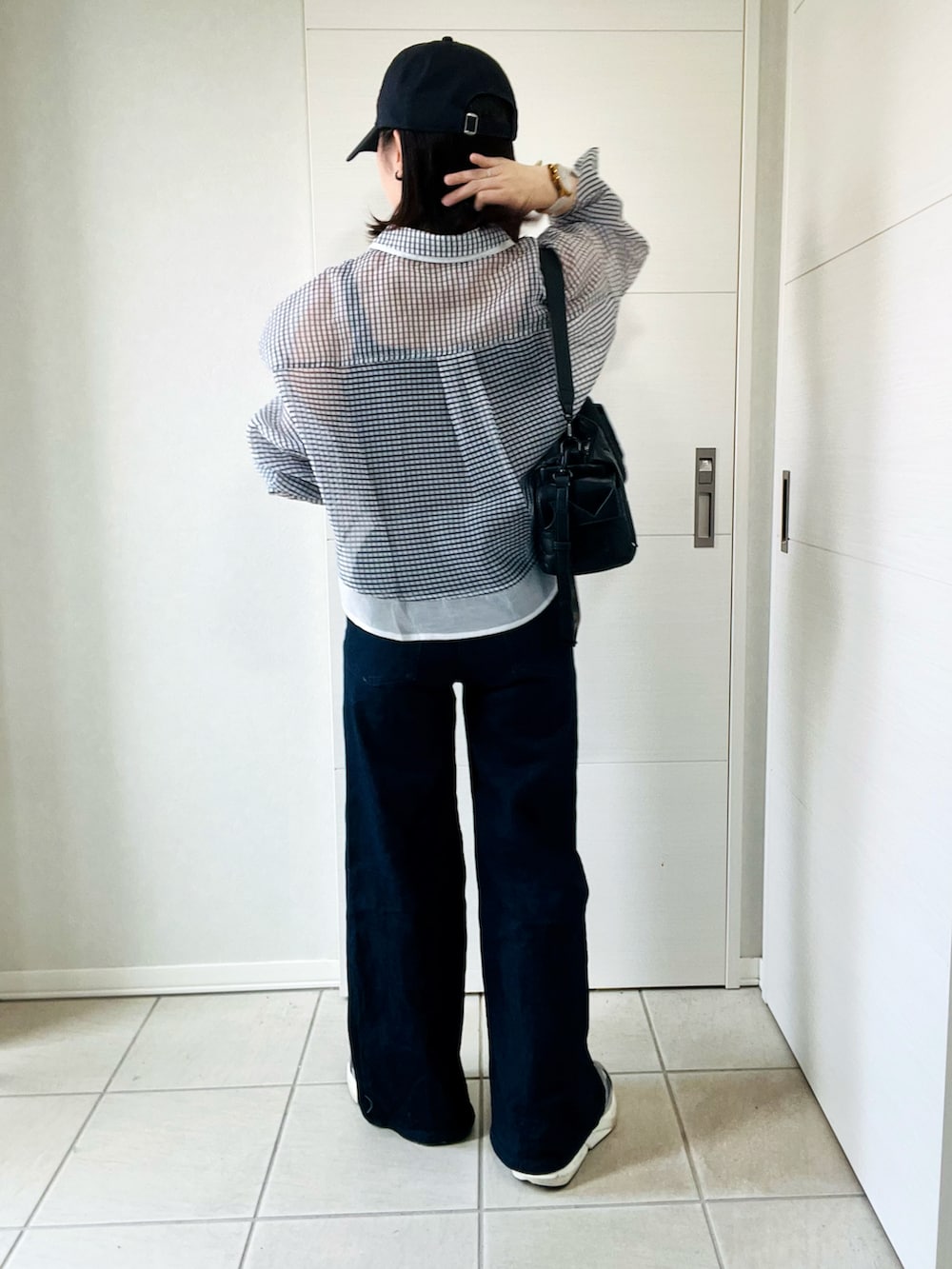 ホワイト系のシャツ/ブラウス、グレー系のスニーカー、ブラック系のハンドバッグを着用したレディースの夏コーディネートの5枚目の写真