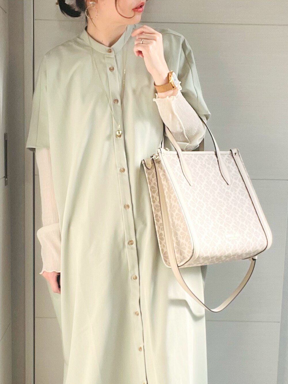 グリーン系のワンピース、その他のハンドバッグ、ベージュ系のスニーカーを着用したレディースの春コーディネートの4枚目の写真