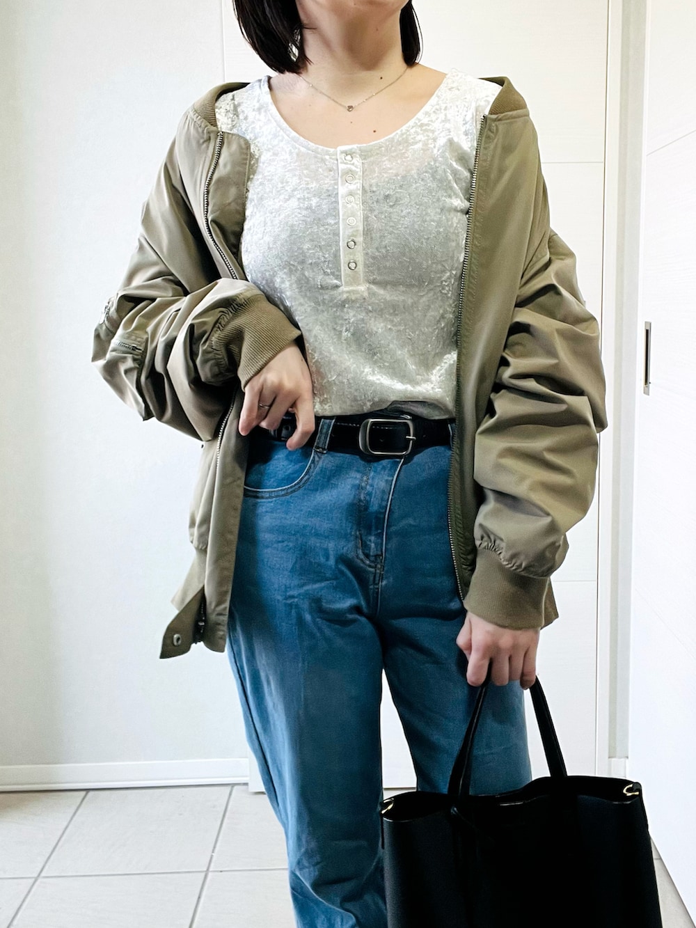 ホワイト系のTシャツ/カットソー、グリーン系のMA-1、ブルー系のデニムパンツを着用したレディースの春コーディネートの3枚目の写真