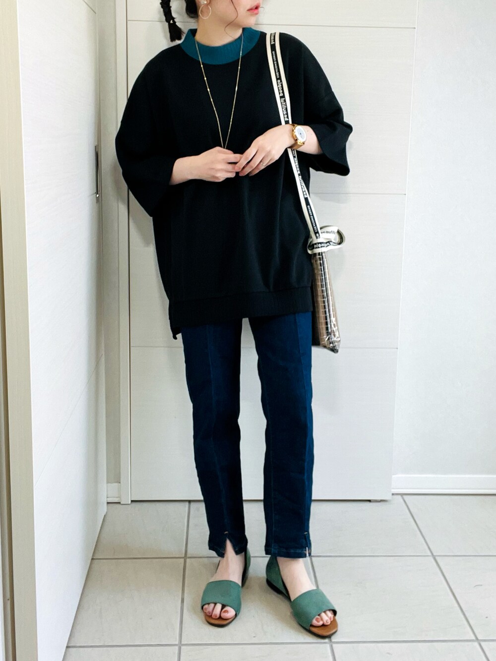 ブラック系のTシャツ/カットソー、ブルー系のデニムパンツ、グリーン系のサンダルを着用したレディースの夏コーディネートの3枚目の写真