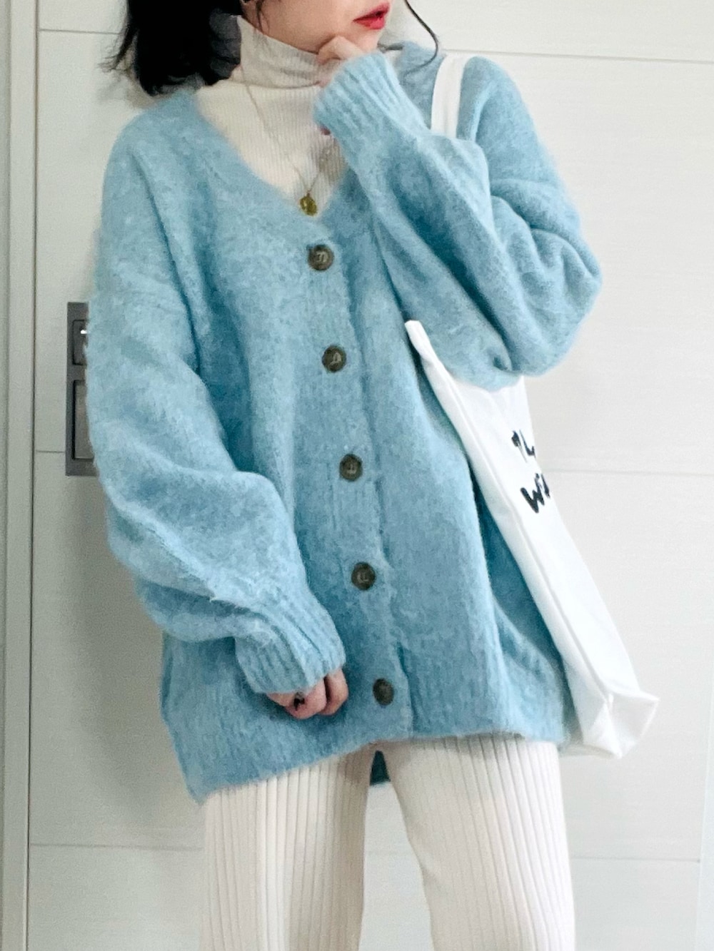 ブルー系のカーディガン/ボレロ、ホワイト系のニット/セーター、ホワイト系のその他パンツを着用したレディースの冬コーディネートの2枚目の写真