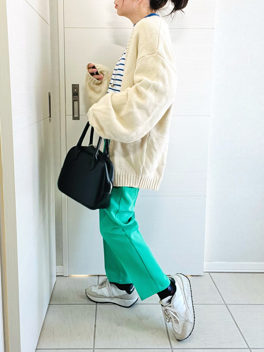 ブルー系のTシャツ/カットソー、ホワイト系のカーディガン/ボレロ、グリーン系のスラックスを着用したレディースの冬コーディネートの3枚目の写真