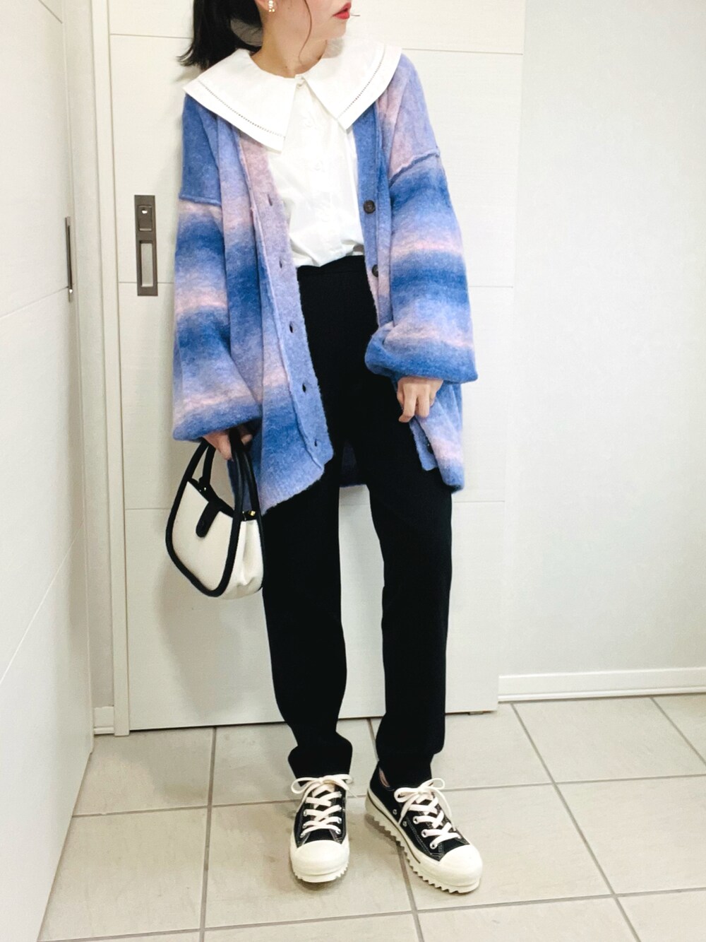 ブルー系のカーディガン/ボレロ、ホワイト系のシャツ/ブラウス、ブラック系のその他パンツを着用したレディースの秋コーディネートの2枚目の写真