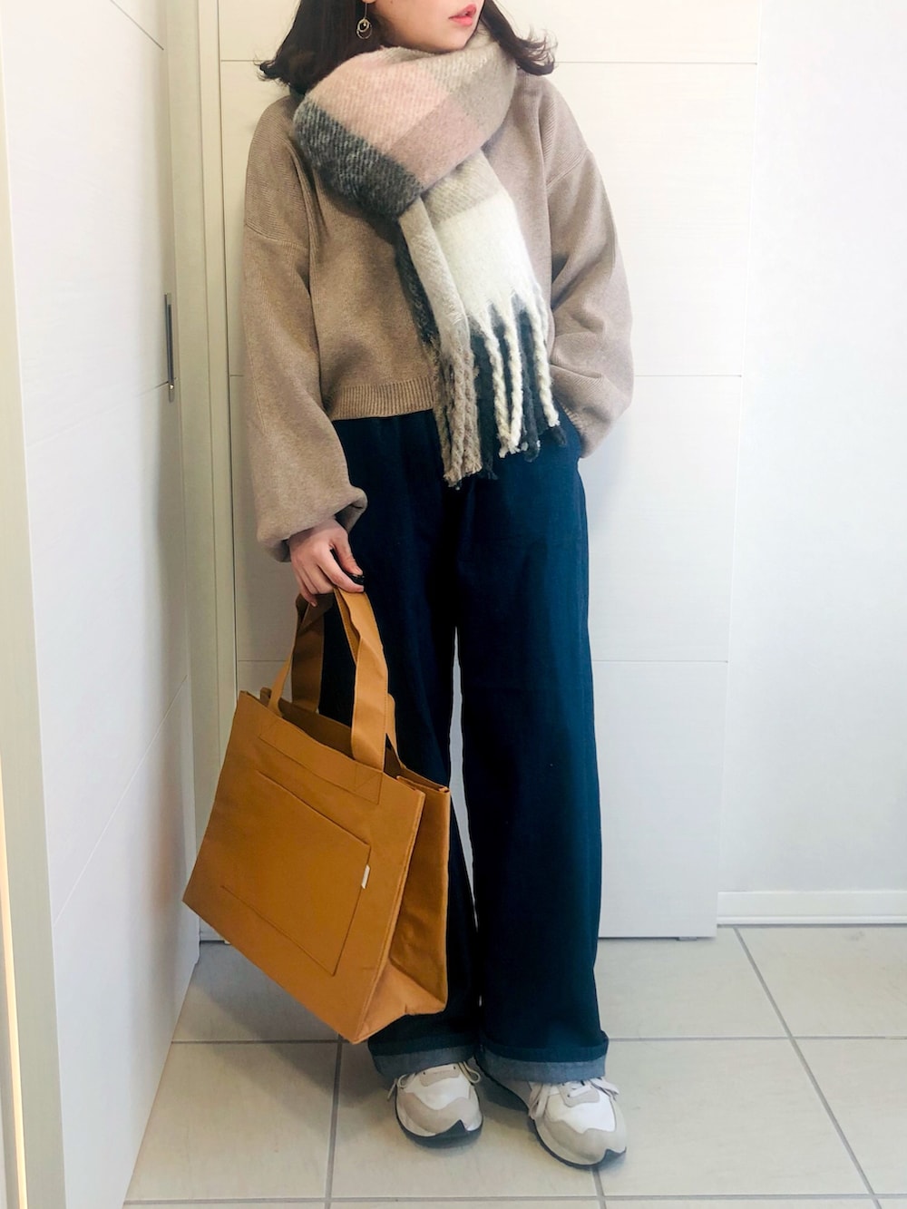 ベージュ系のカーディガン/ボレロ、ブルー系のその他パンツ、ホワイト系のスニーカーを着用したレディースの冬コーディネートの2枚目の写真