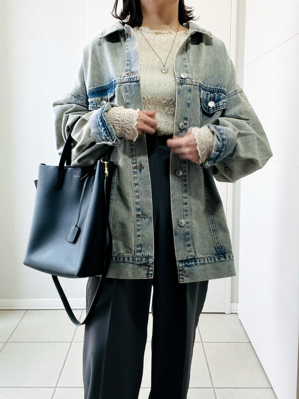 ブルー系のデニムジャケット、ホワイト系のTシャツ/カットソー、グレー系のスラックスを着用したレディースの春コーディネートの2枚目の写真