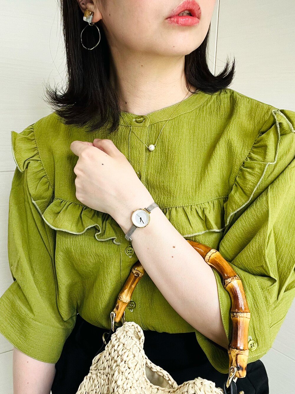 グリーン系のシャツ/ブラウス、ブラック系のスラックス、ブラック系のサンダルを着用したレディースの夏コーディネートの2枚目の写真