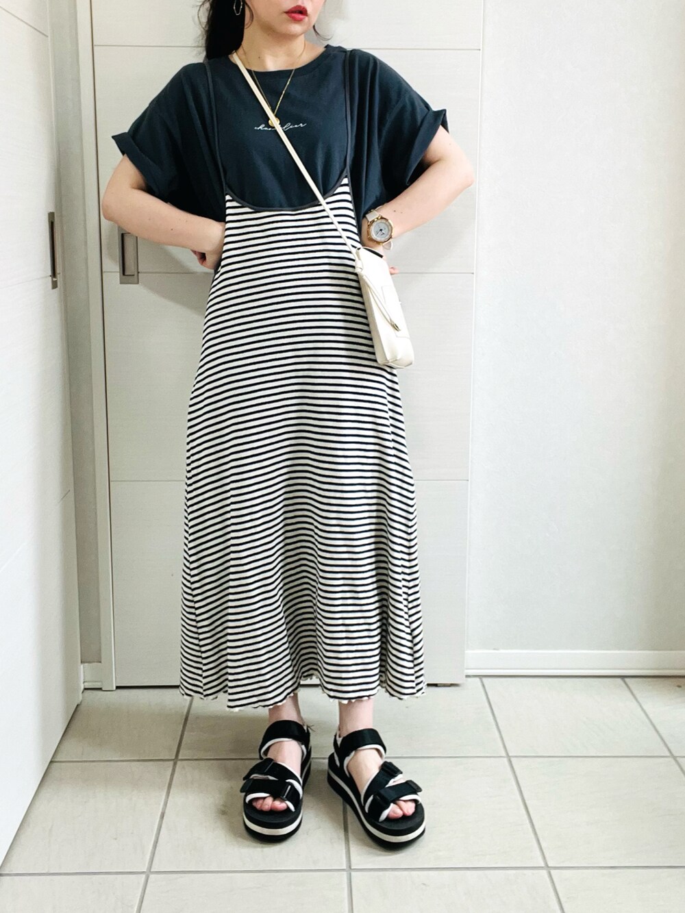 ブルー系のワンピース、グレー系のTシャツ/カットソー、ブラック系のサンダルを着用したレディースの夏コーディネートの2枚目の写真