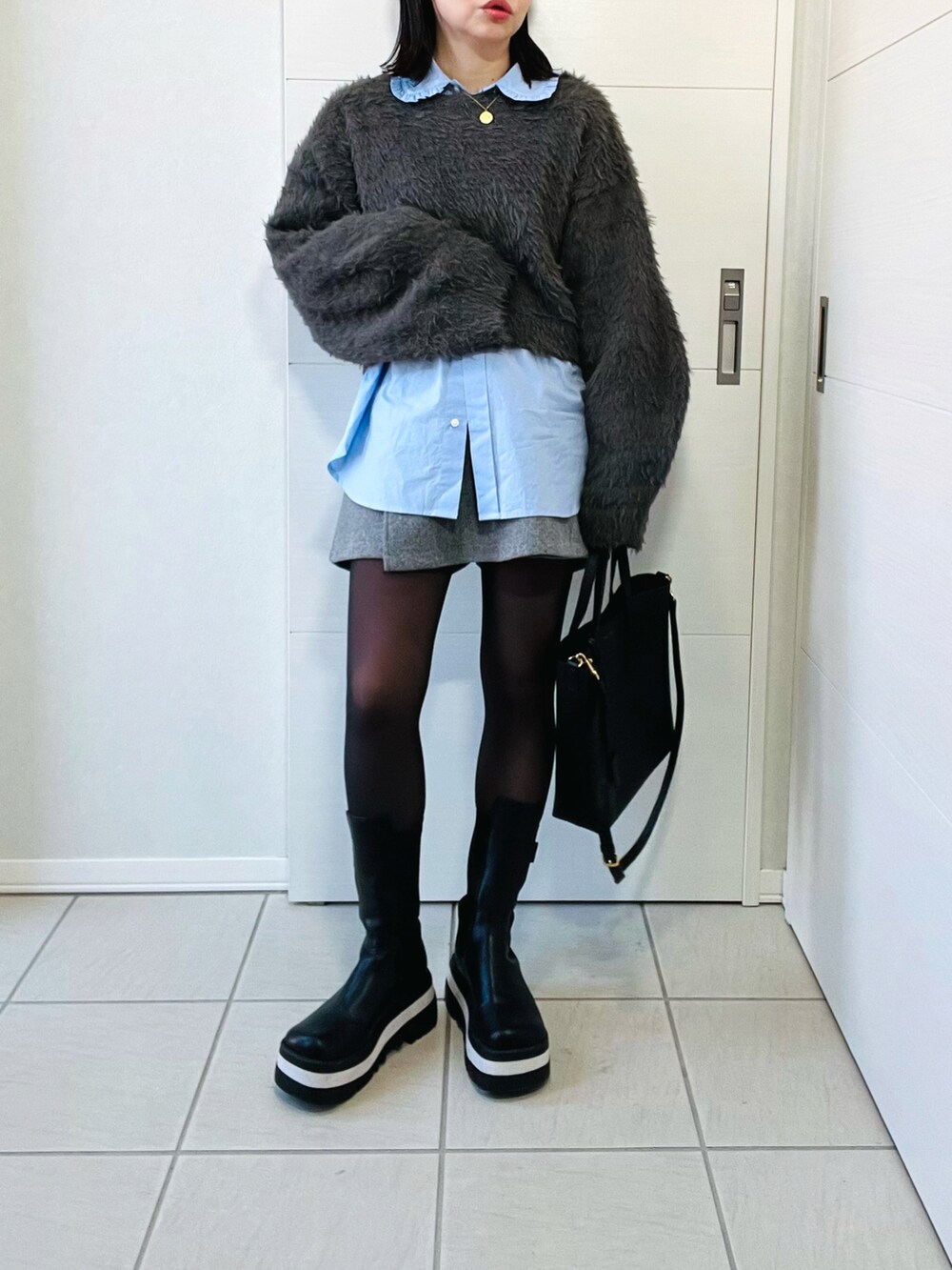 グレー系のニット/セーター、ブルー系のシャツ/ブラウス、グレー系のその他パンツを着用したレディースの冬コーディネートの4枚目の写真