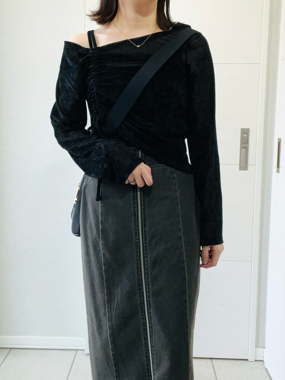 ブラック系のTシャツ/カットソー、ブラック系のブーツ、ブラック系のスカートを着用したレディースの秋コーディネートの2枚目の写真