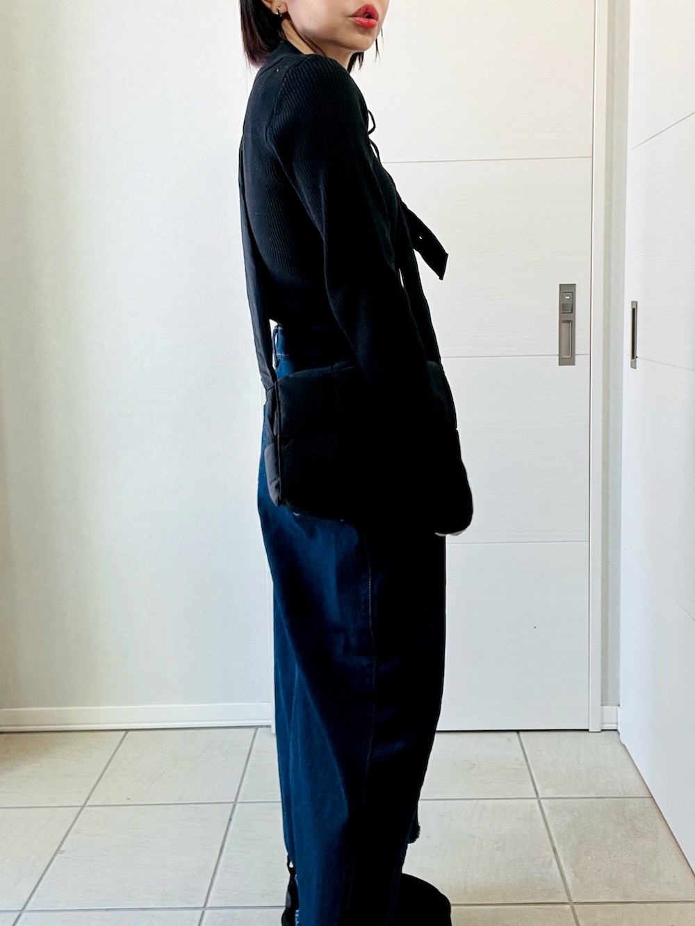 ブラック系のニット/セーター、ブルー系のスカート、ブラック系のブーツを着用したレディースの冬コーディネートの4枚目の写真