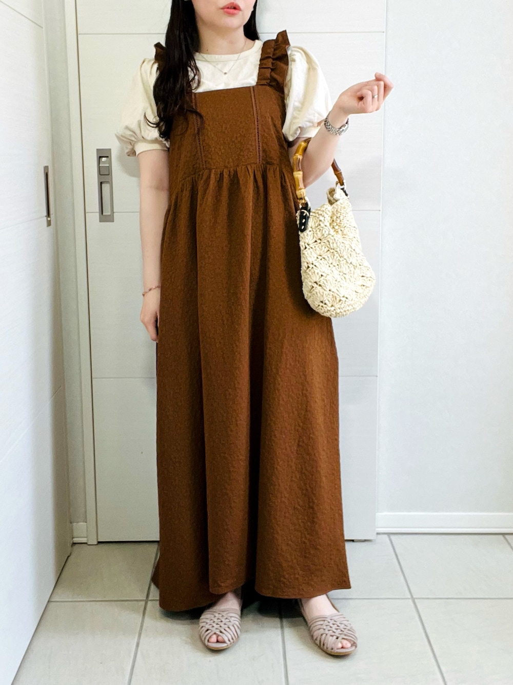 ブラウン系のワンピース、グレー系のサンダル、ベージュ系のショルダーバッグを着用したレディースの春コーディネートの5枚目の写真