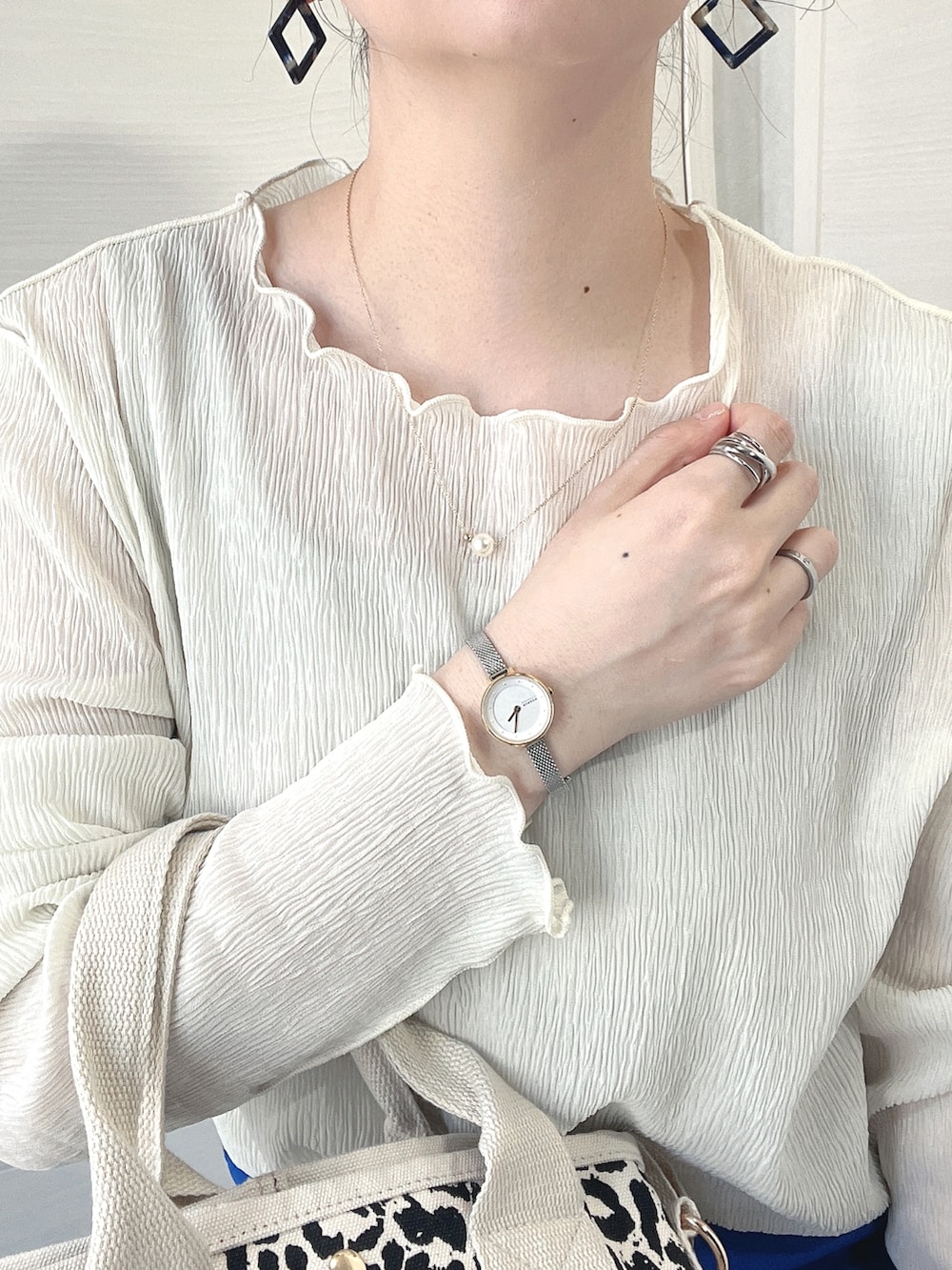 ブルー系のスラックス、ホワイト系のサンダル、その他のトートバッグを着用したレディースの春コーディネートの2枚目の写真