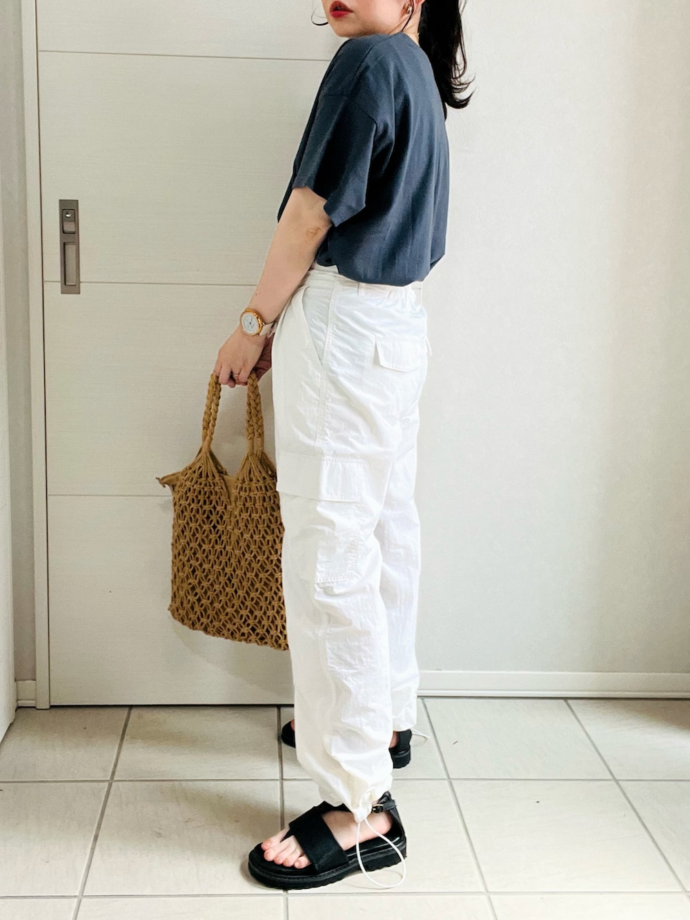 グレー系のTシャツ/カットソー、ホワイト系のその他パンツ、ブラック系のサンダルを着用したレディースの夏コーディネートの4枚目の写真