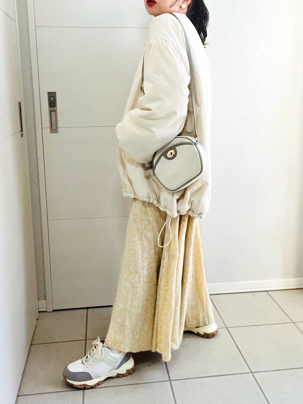 ホワイト系のブルゾン、グレー系のスウェット、イエロー系のスカートを着用したレディースの冬コーディネートの5枚目の写真