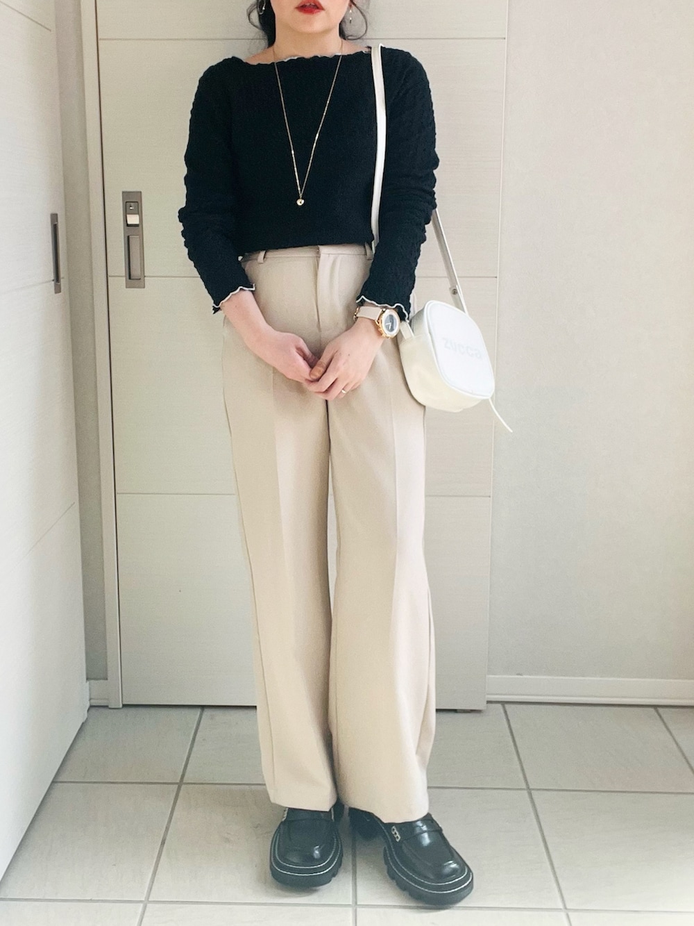 ブラック系のTシャツ/カットソー、ホワイト系のスラックス、ブラック系のローファーを着用したレディースの春コーディネートの3枚目の写真