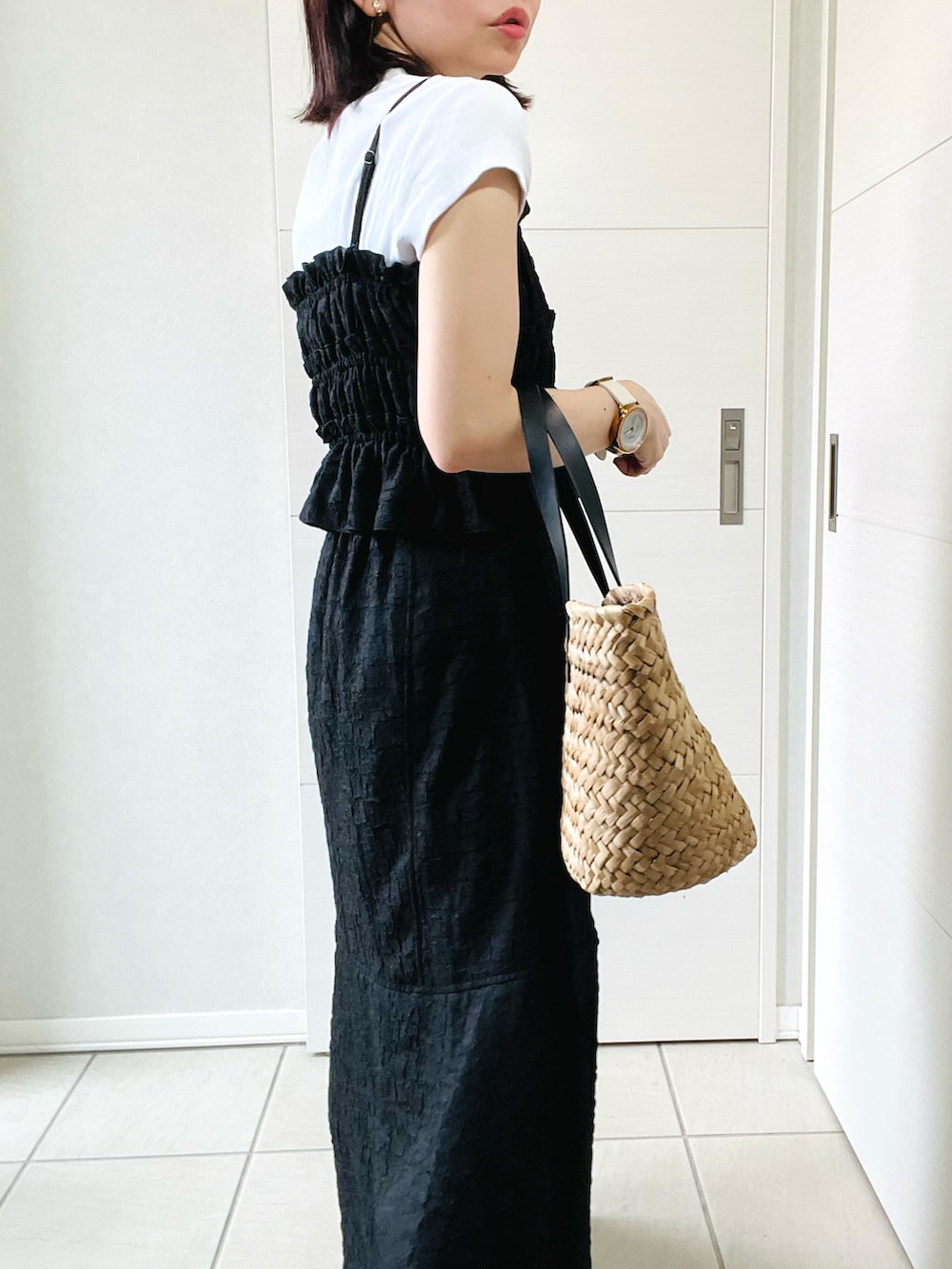ブラック系のワンピース、ホワイト系のスニーカー、ブラック系のかごバッグを着用したレディースの夏コーディネートの3枚目の写真