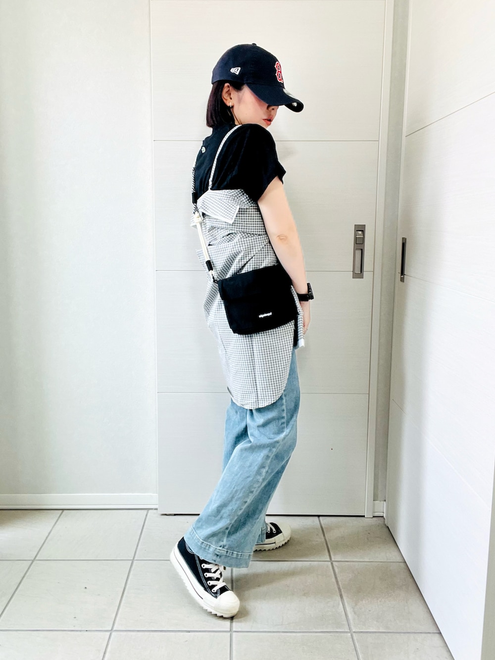 ホワイト系のシャツ/ブラウス、ブラック系のスニーカー、ブルー系のデニムパンツを着用したレディースの夏コーディネートの4枚目の写真