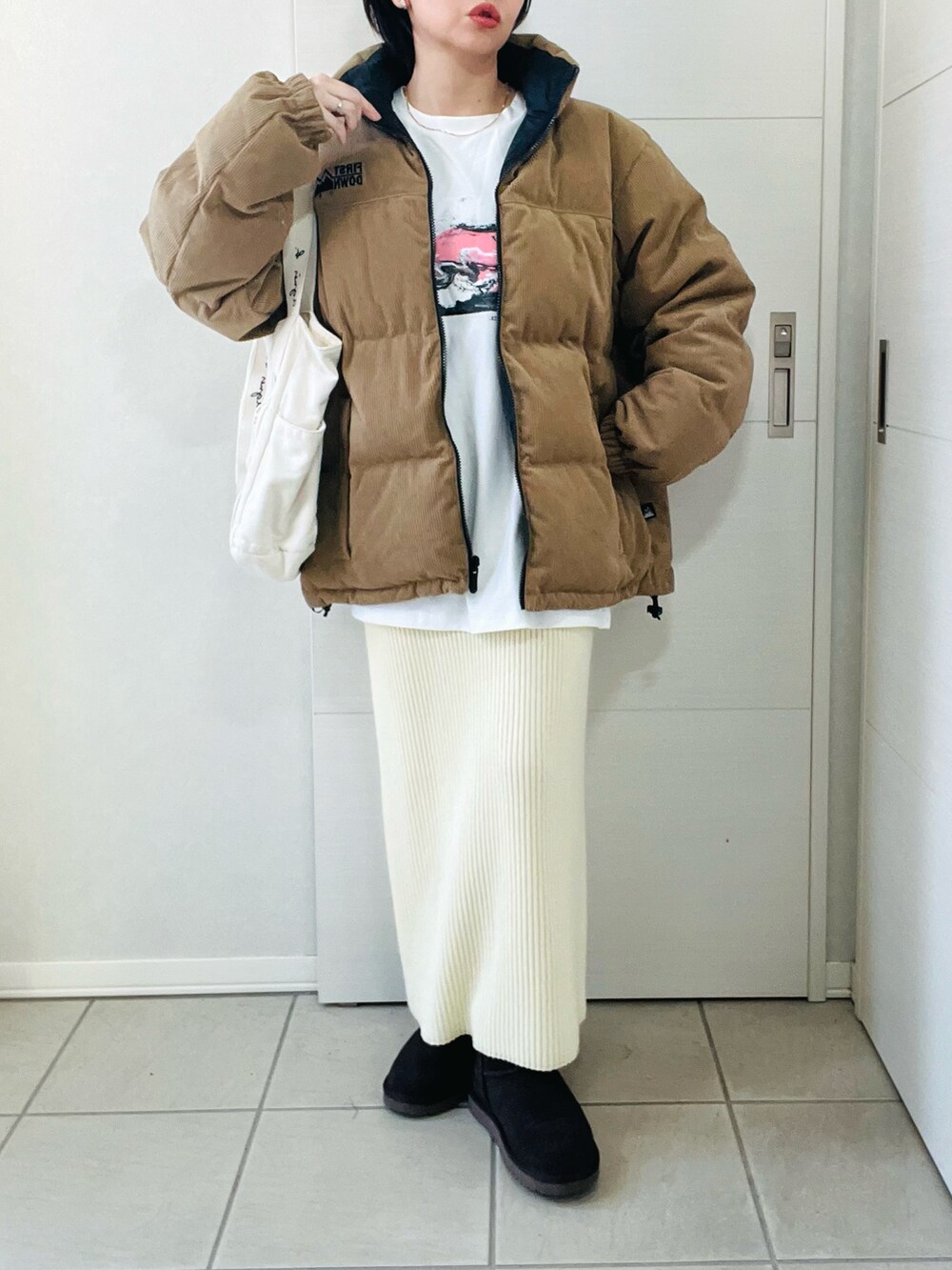 ベージュ系のダウンジャケット/コート、ホワイト系のTシャツ/カットソー、ホワイト系のスカートを着用したレディースの秋コーディネートの4枚目の写真