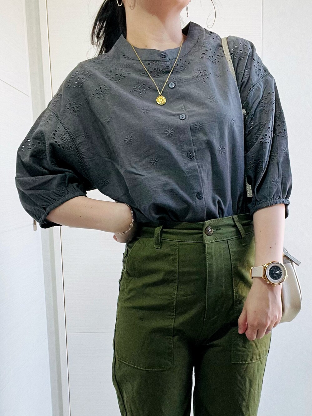 グレー系のシャツ/ブラウス、ブラック系のパンプス、ホワイト系のショルダーバッグを着用したレディースの春コーディネートの2枚目の写真