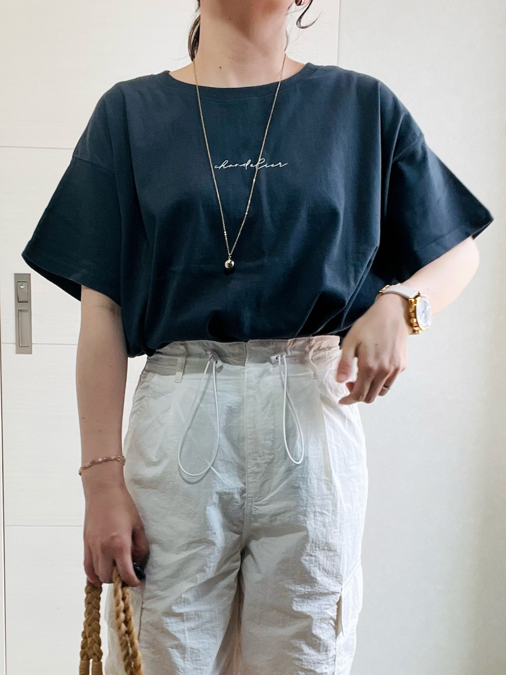 グレー系のTシャツ/カットソー、ホワイト系のその他パンツ、ブラック系のサンダルを着用したレディースの夏コーディネートの2枚目の写真