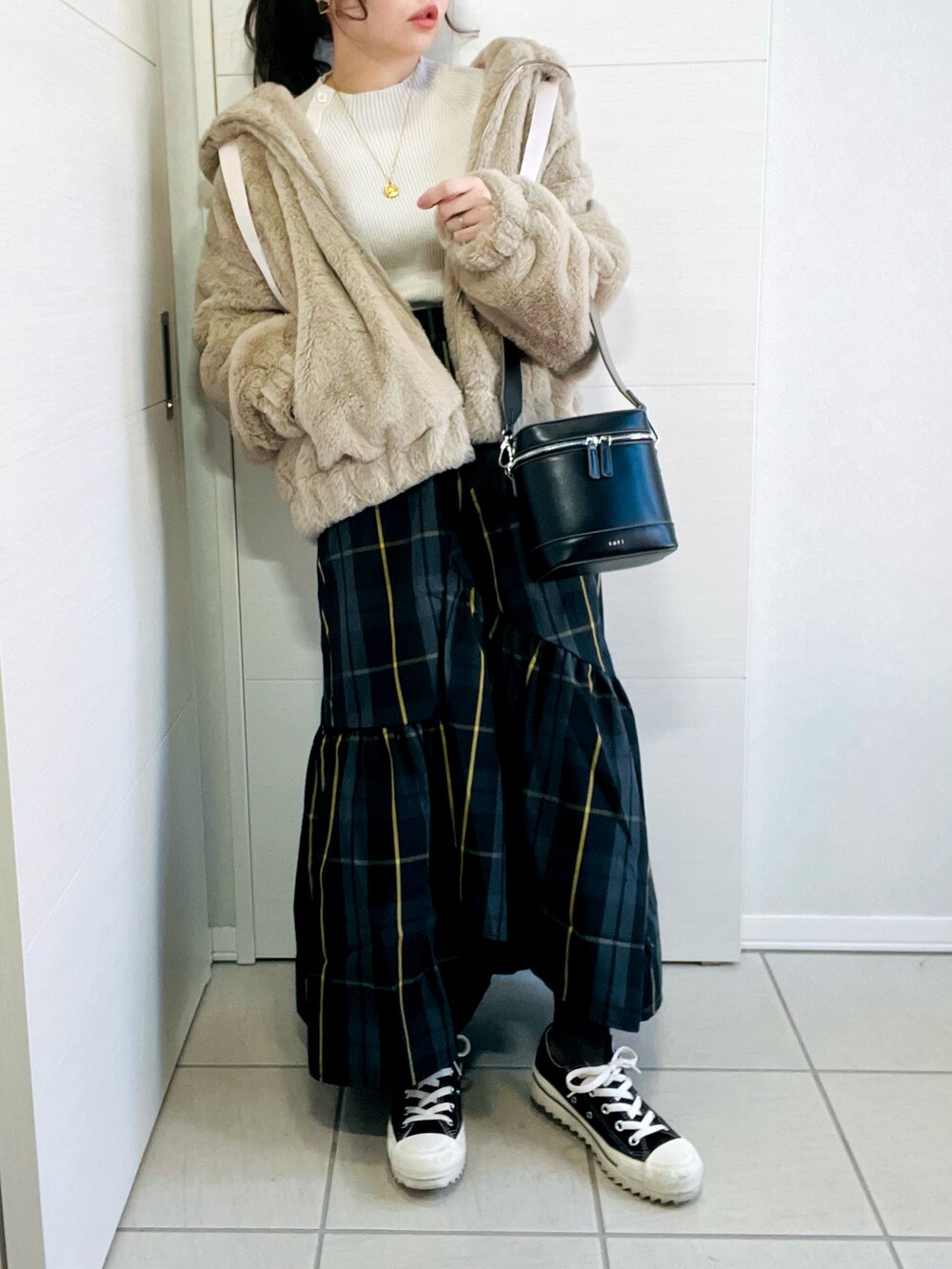 ベージュ系のブルゾン、ブラック系のスカート、ブラック系のスニーカーを着用したレディースの冬コーディネートの3枚目の写真