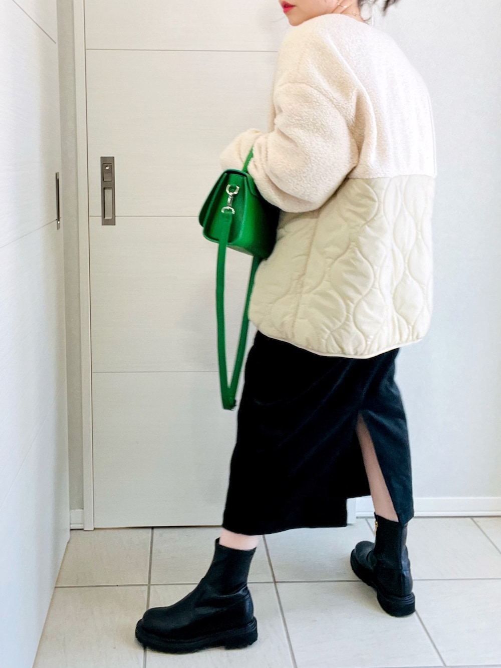 ホワイト系のその他アウター、グレー系のスウェット、ブラック系のジャンパースカートを着用したレディースの冬コーディネートの3枚目の写真