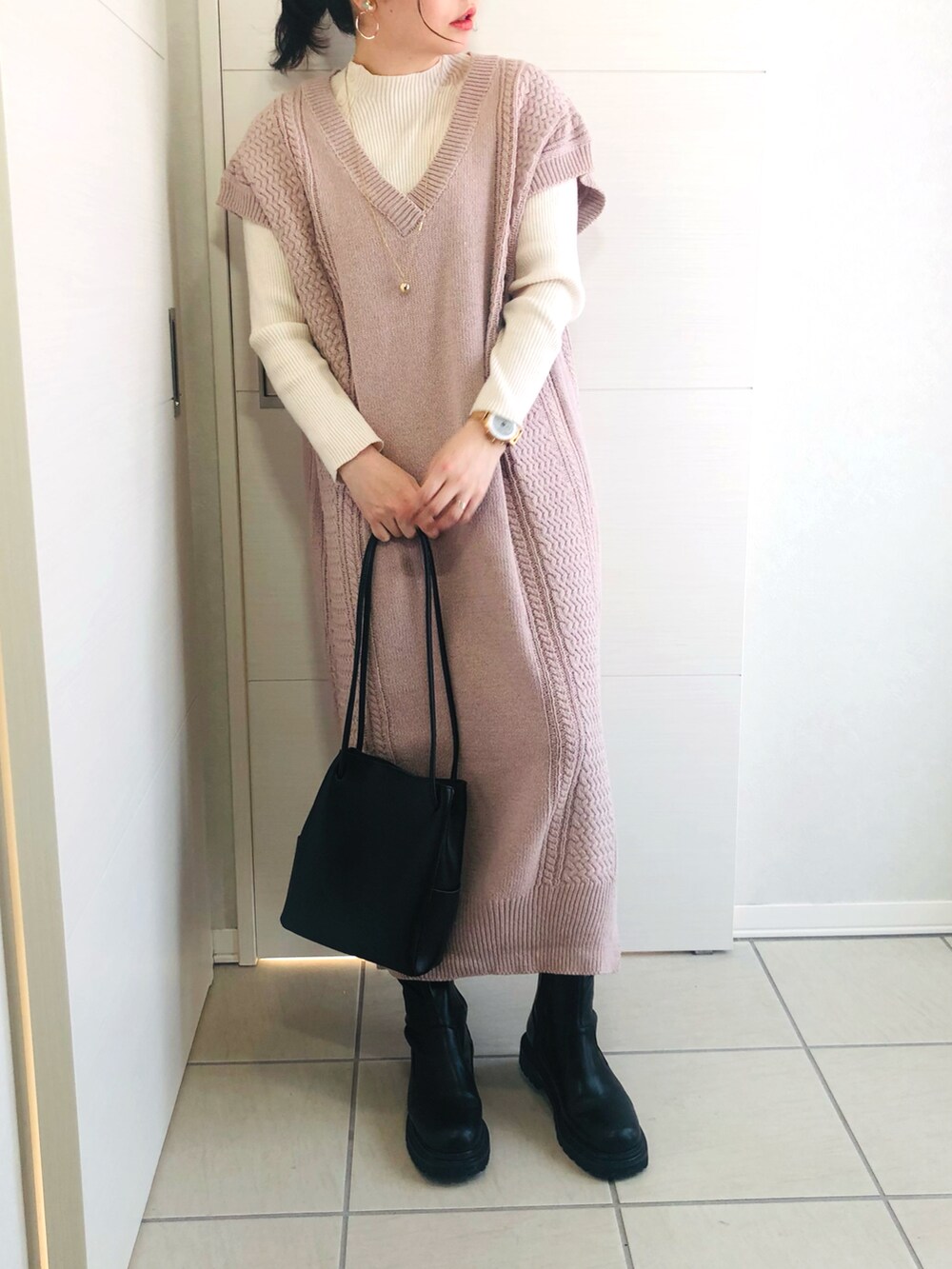 パープル系のワンピース、ブラック系のブーツ、ブラック系のショルダーバッグを着用したレディースの冬コーディネートの2枚目の写真