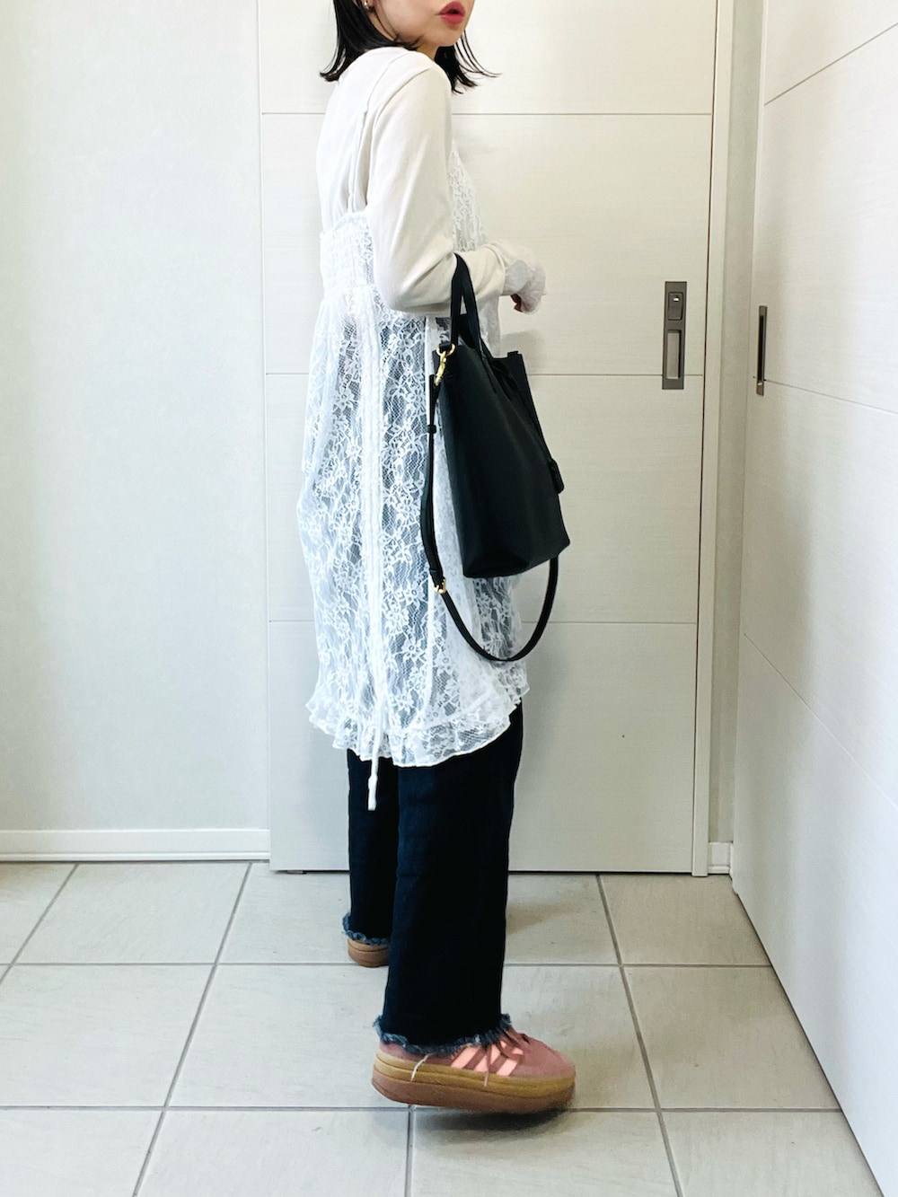 ホワイト系のチュニック、ホワイト系のTシャツ/カットソー、ブルー系のデニムパンツを着用したレディースの春コーディネートの5枚目の写真