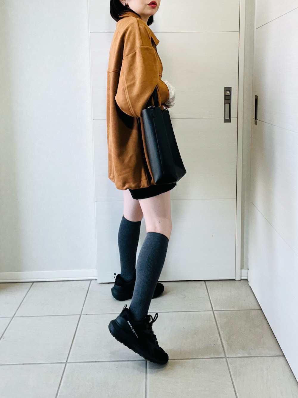 ホワイト系のTシャツ/カットソー、ベージュ系のブルゾン、ブラック系のスニーカーを着用したレディースの春コーディネートの5枚目の写真