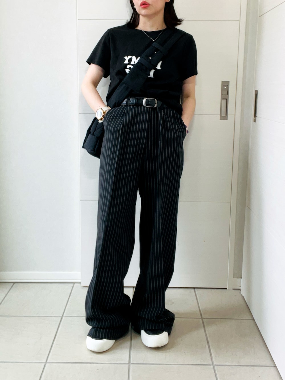 ブラック系のデニムパンツ、ブラック系のTシャツ/カットソー、ブラック系のスニーカーを着用したレディースの秋コーディネートの4枚目の写真