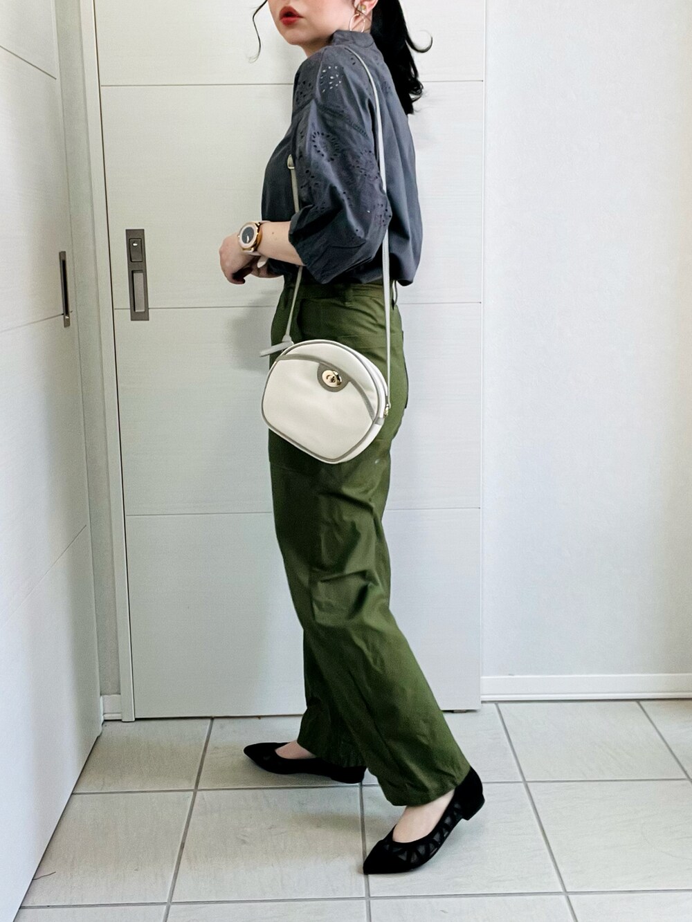グレー系のシャツ/ブラウス、ブラック系のパンプス、ホワイト系のショルダーバッグを着用したレディースの春コーディネートの4枚目の写真