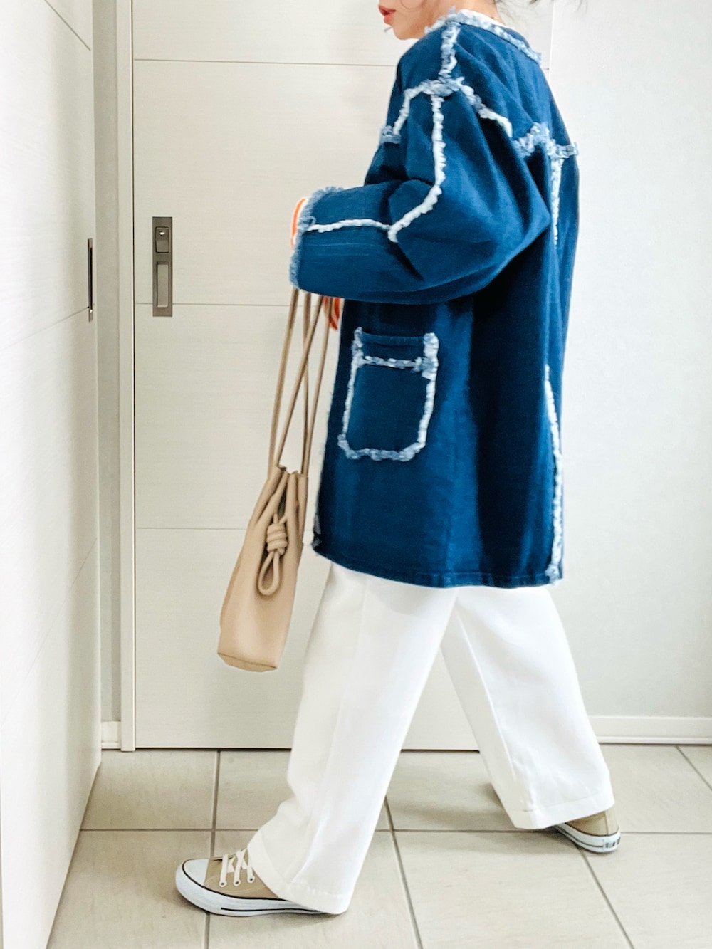 オレンジ系のTシャツ/カットソー、ブルー系のデニムジャケット、ホワイト系のサロペット/オーバーオールを着用したレディースの春コーディネートの4枚目の写真