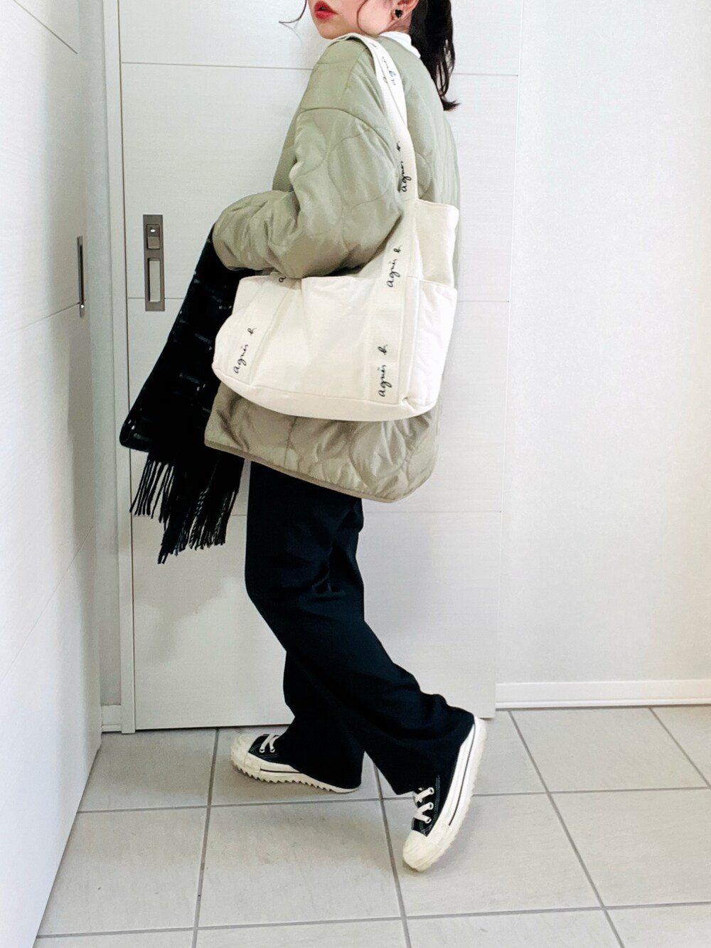 ホワイト系のTシャツ/カットソー、グリーン系のノーカラージャケット、ブラック系のスラックスを着用したレディースの冬コーディネートの4枚目の写真