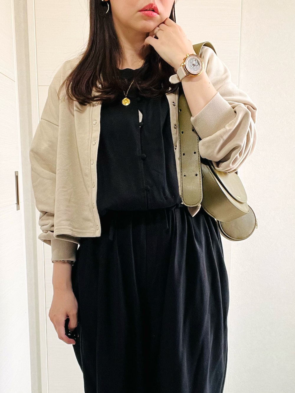 ブラック系のサロペット/オーバーオール、ベージュ系のカーディガン/ボレロ、ホワイト系のスニーカーを着用したレディースの夏コーディネートの3枚目の写真