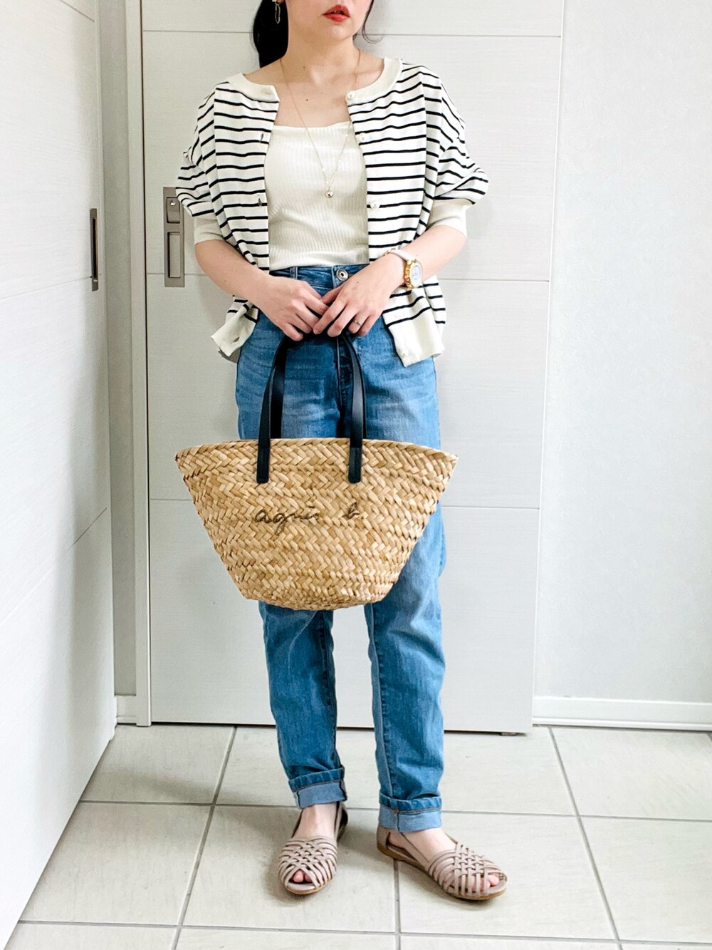 ホワイト系のタンクトップ、ホワイト系のカーディガン/ボレロ、ブルー系のデニムパンツを着用したレディースの夏コーディネートの3枚目の写真