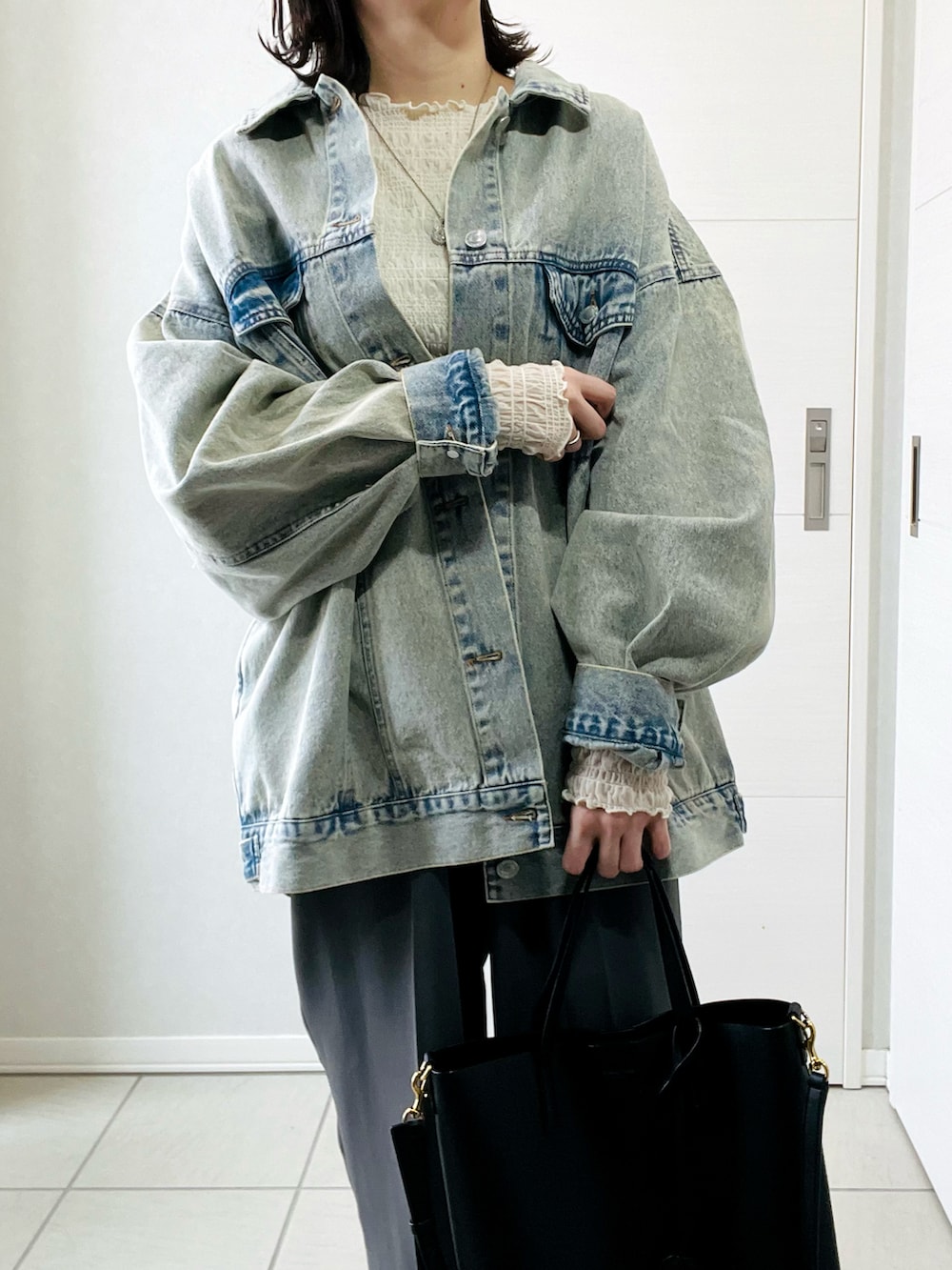 ブルー系のデニムジャケット、ホワイト系のTシャツ/カットソー、グレー系のスラックスを着用したレディースの春コーディネートの3枚目の写真