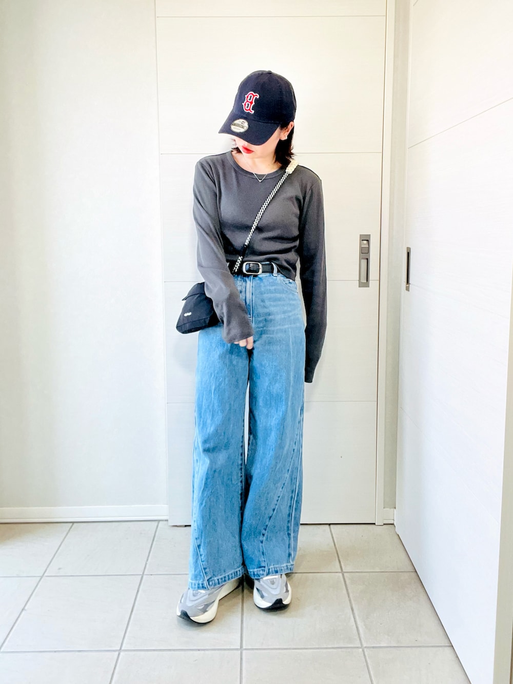 グレー系のスニーカー、グレー系のTシャツ/カットソー、ブラック系のショルダーバッグを着用したレディースの夏コーディネートの5枚目の写真
