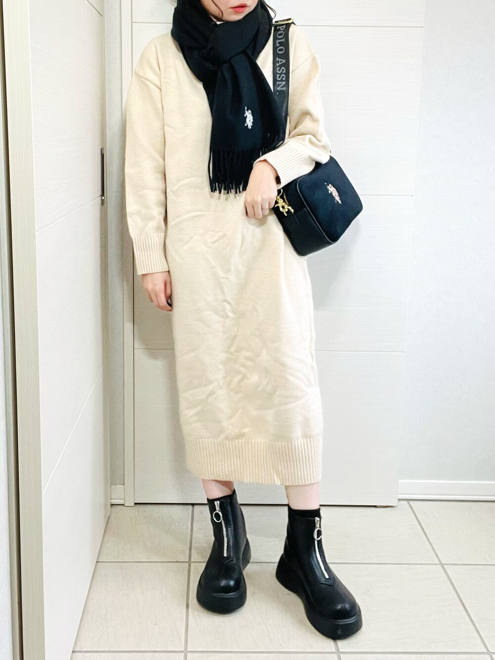 ブラック系のショルダーバッグ、ブラック系のブーツ、ホワイト系のワンピースを着用したレディースの秋コーディネートの4枚目の写真