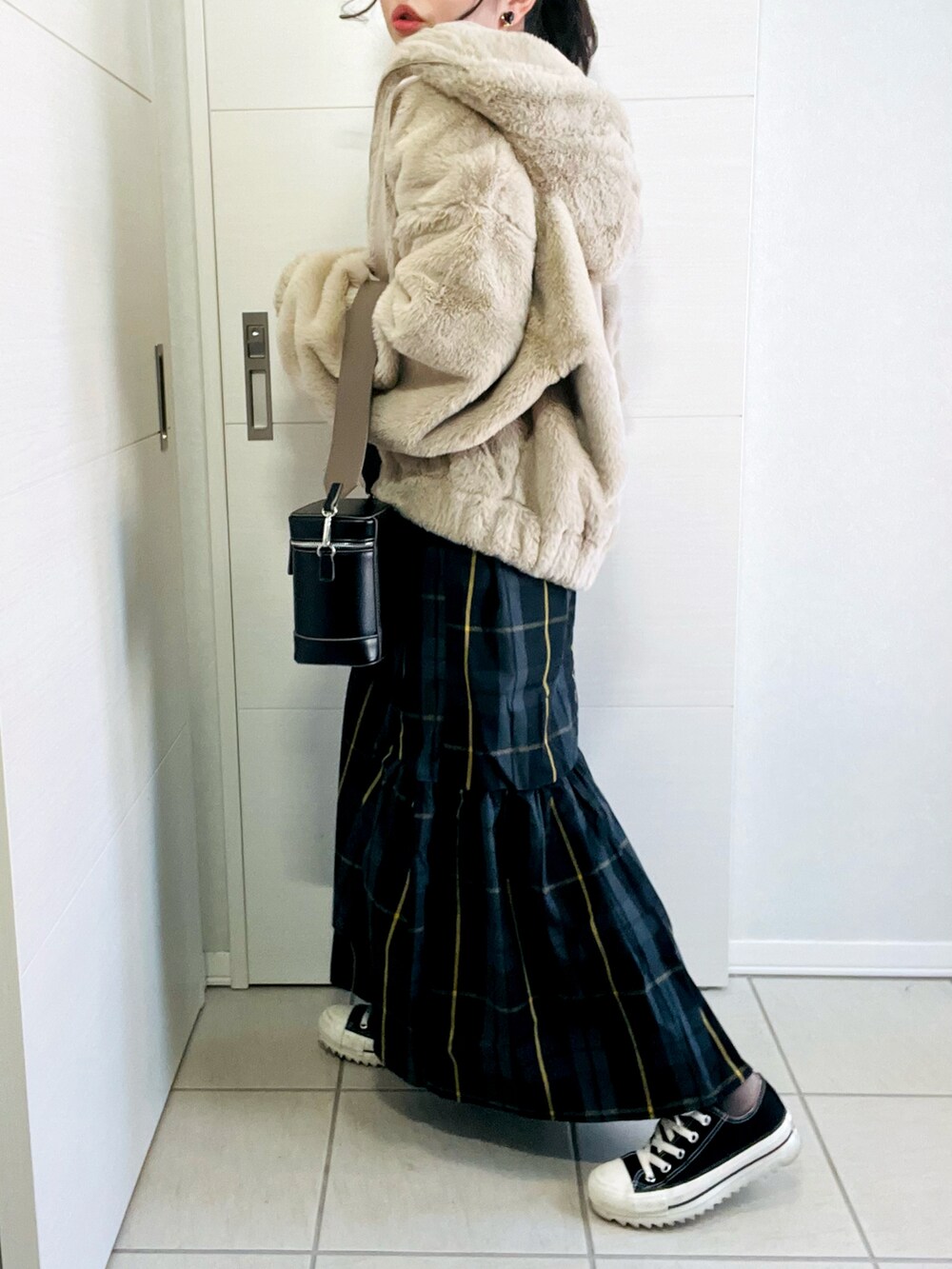 ベージュ系のブルゾン、ブラック系のスカート、ブラック系のスニーカーを着用したレディースの冬コーディネートの5枚目の写真