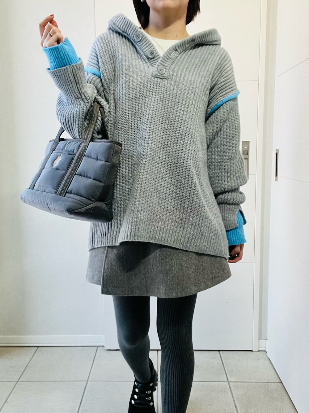 グレー系のニット/セーター、ブラック系のブーツ、グレー系のその他パンツを着用したレディースの冬コーディネートの2枚目の写真