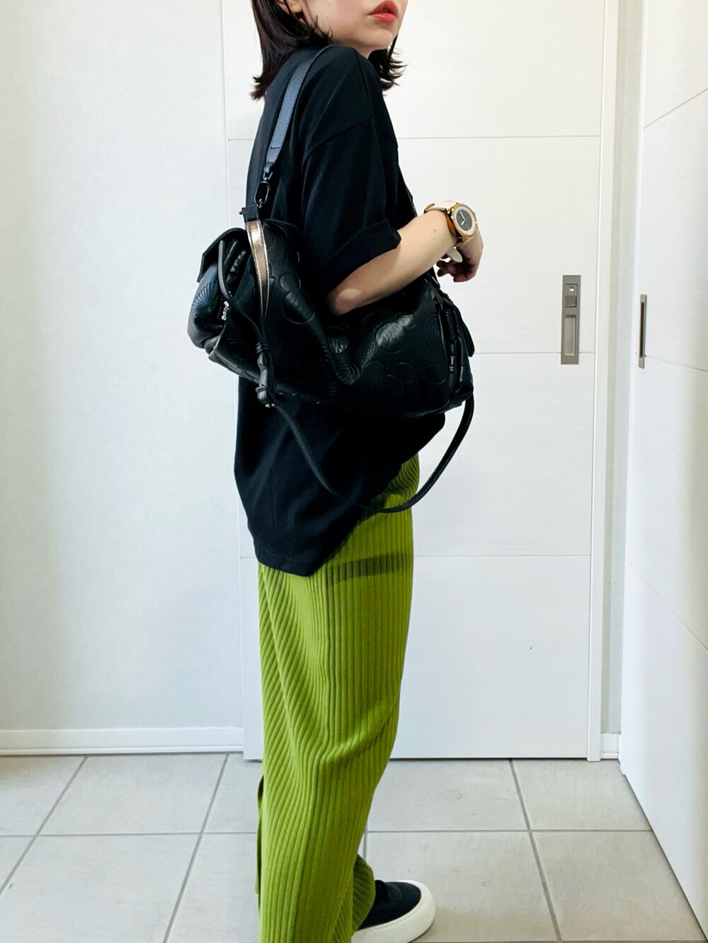 ブラック系のハンドバッグ、ブラック系のスニーカー、ブラック系のTシャツ/カットソーを着用したレディースの夏コーディネートの4枚目の写真