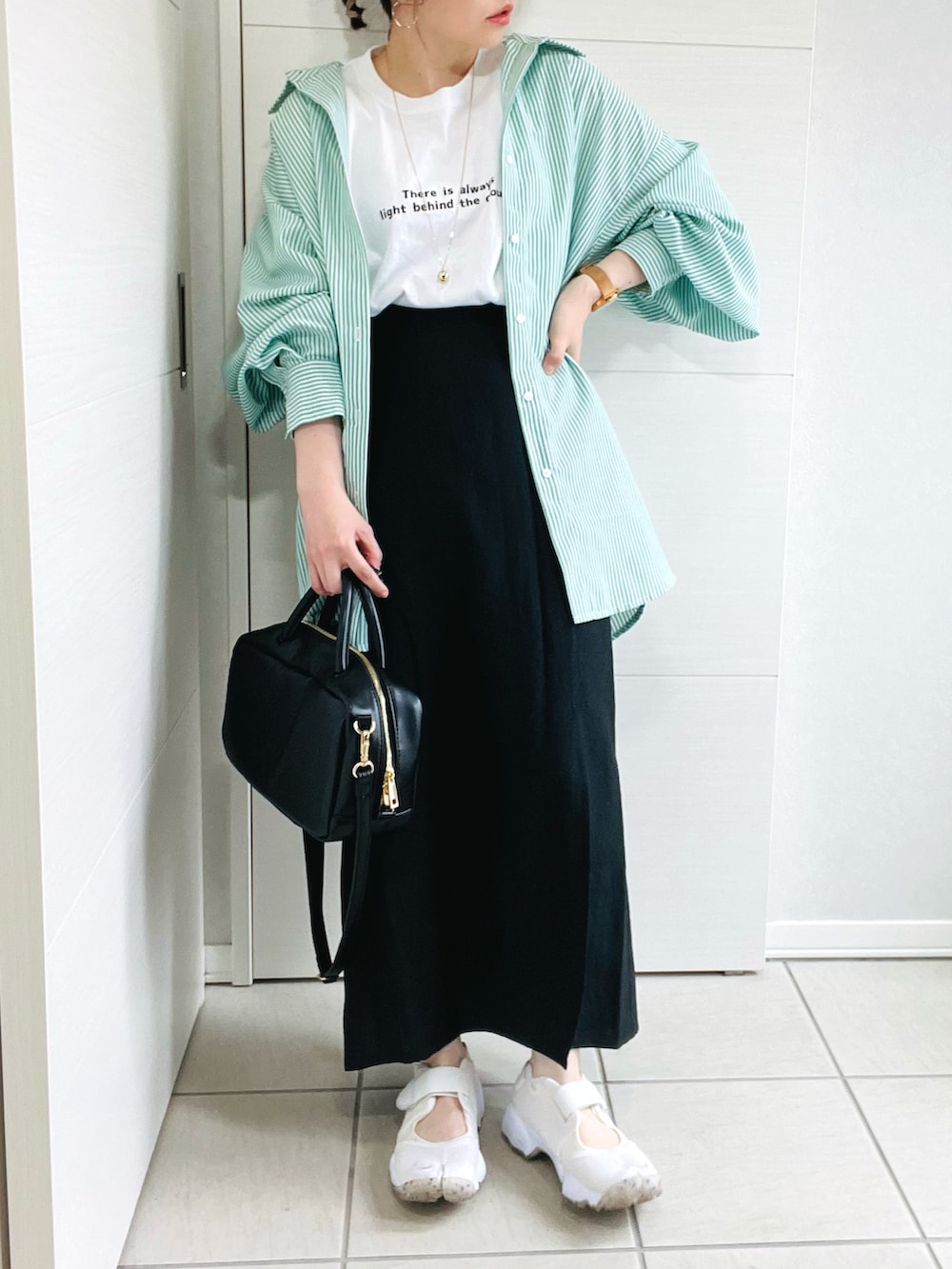 ブラック系のTシャツ/カットソー、グリーン系のシャツ/ブラウス、ホワイト系のサンダルを着用したレディースの春コーディネートの3枚目の写真