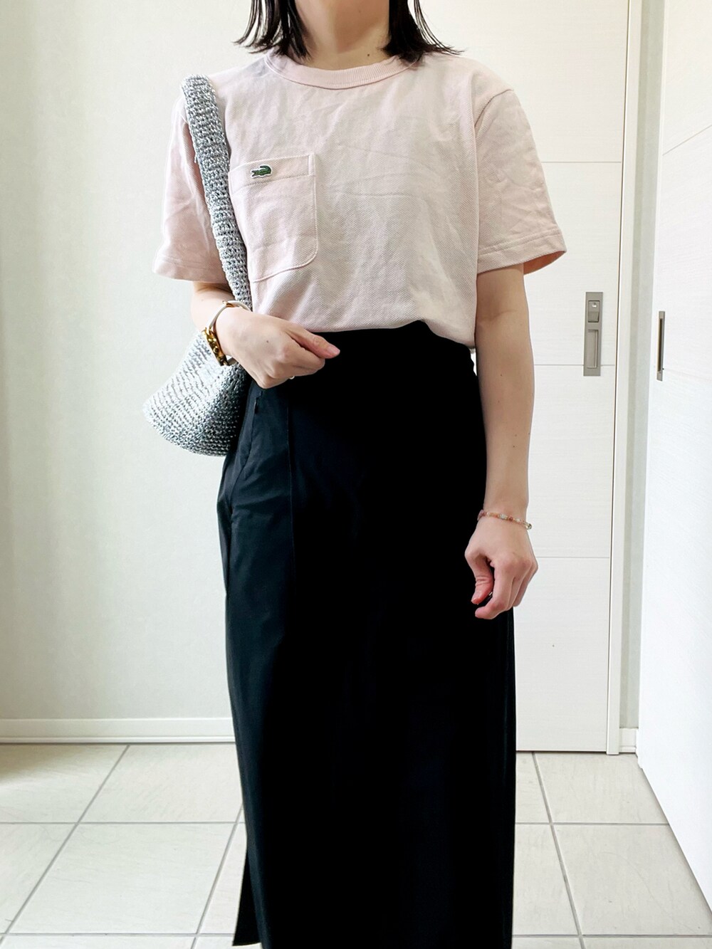 ピンク系のTシャツ/カットソー、ブラック系のスカート、レッド系のスニーカーを着用したレディースの春コーディネートの2枚目の写真