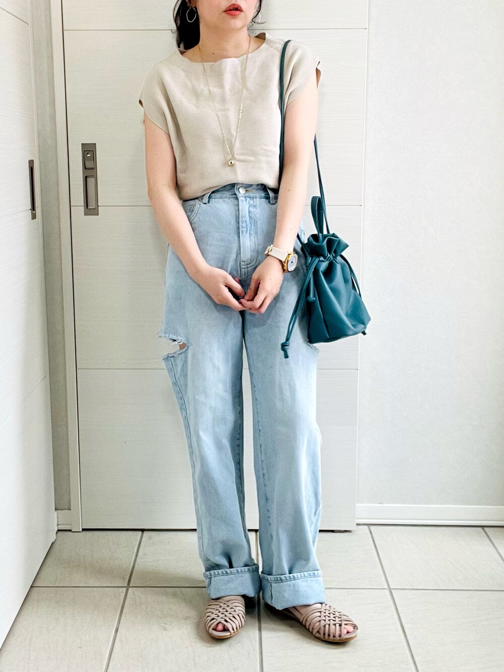 ベージュ系のニット/セーター、ブルー系のデニムパンツ、グレー系のサンダルを着用したレディースの夏コーディネートの4枚目の写真